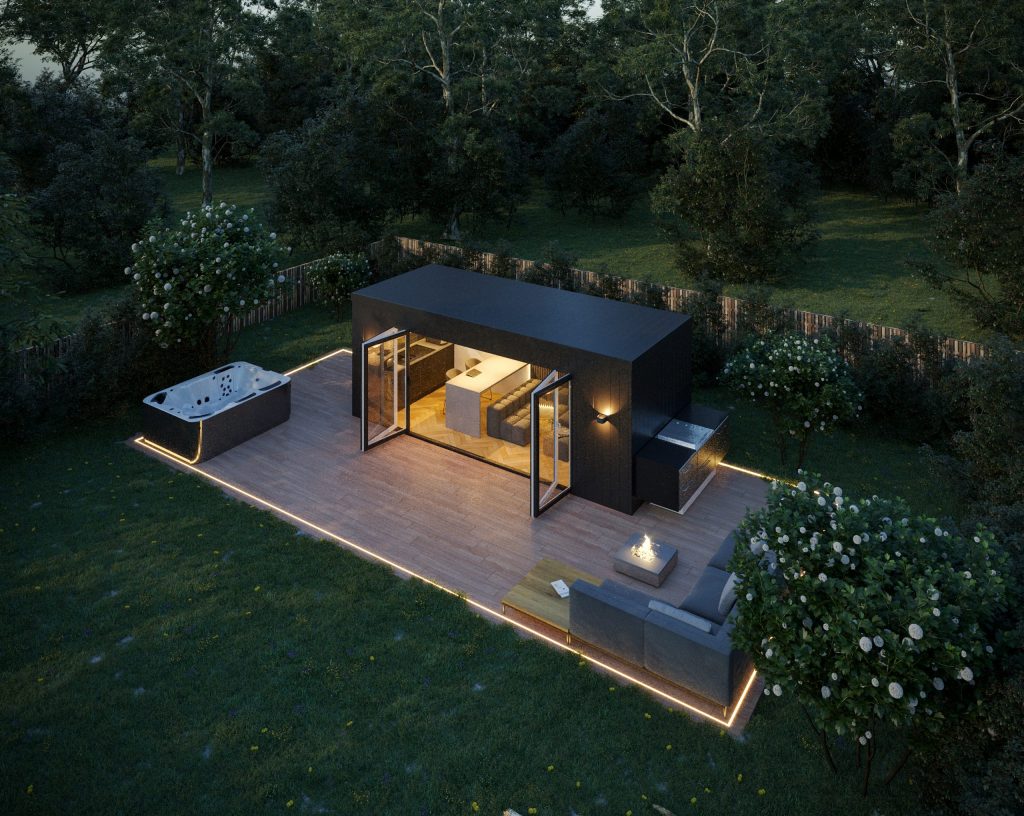 Nightime aeriel view of an ultra modern dark grey cladded garden room with outside seating area, outside cooking area, decking and hot tub, featuring external mood lighting around perimeter
